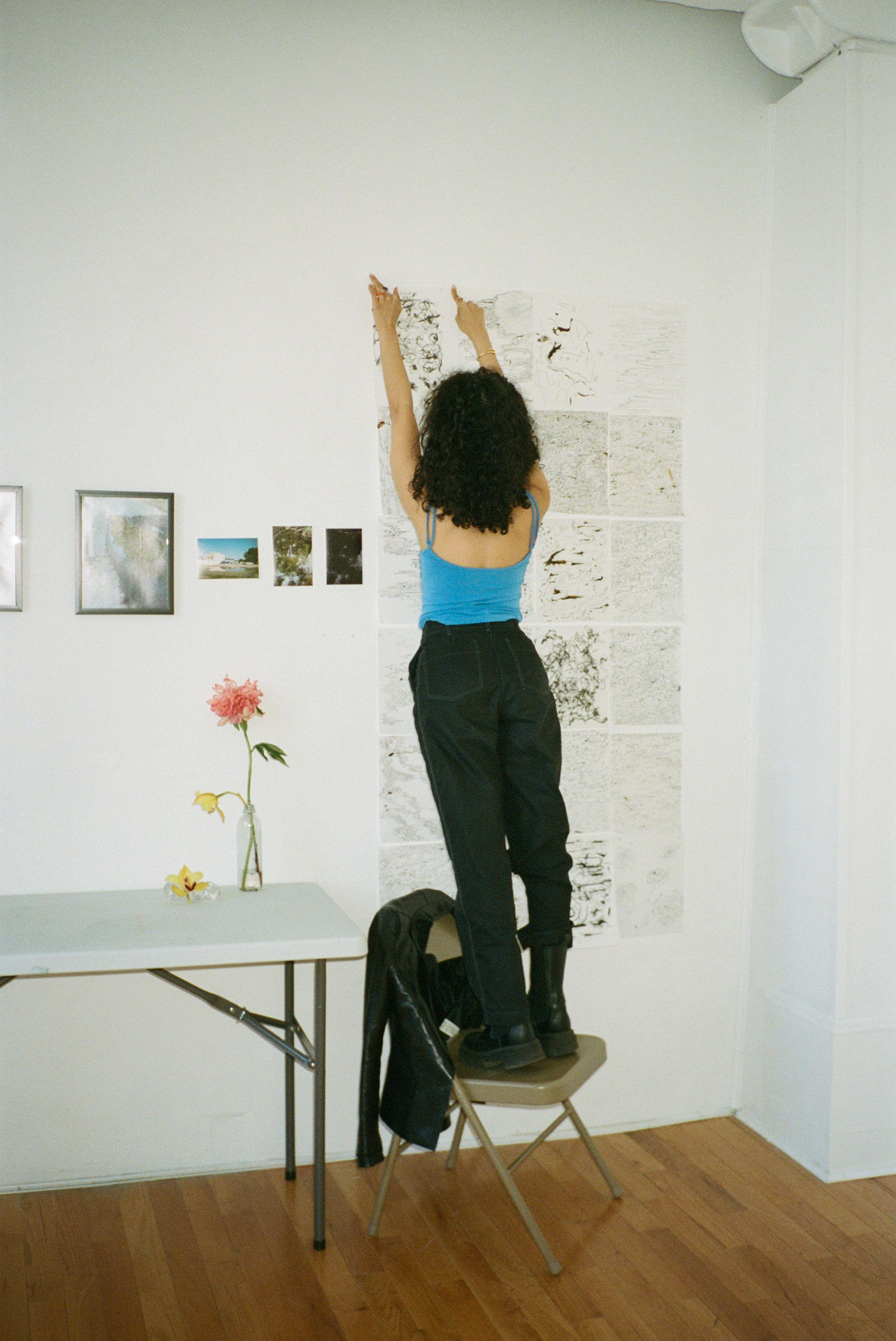 Mashael putting work up in her studio