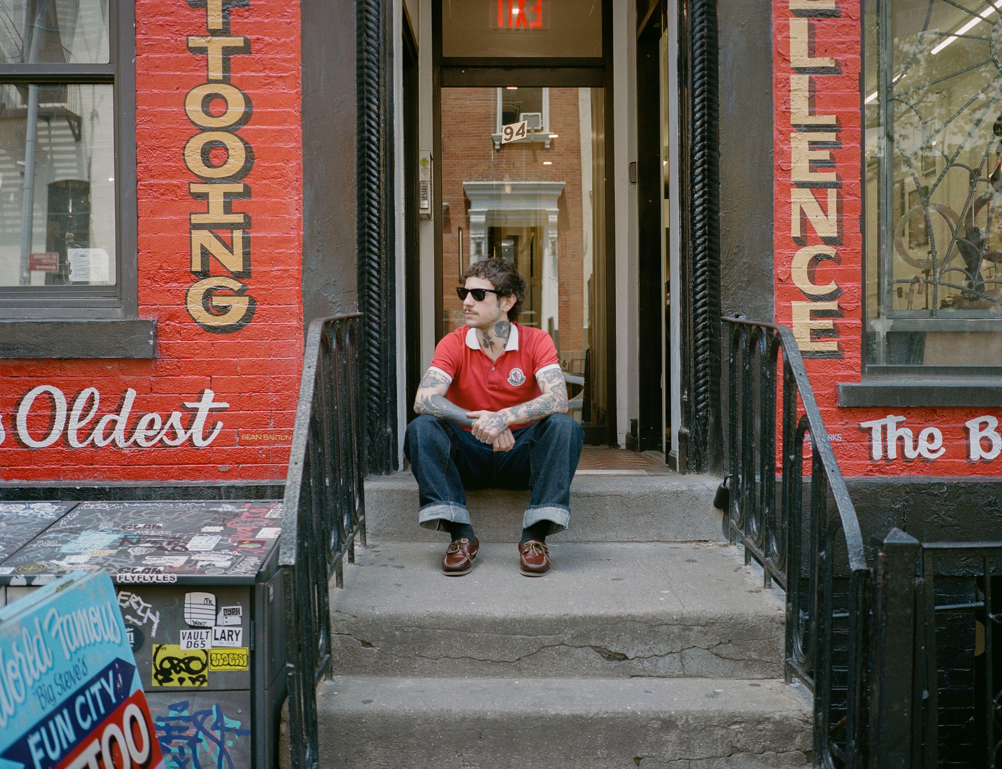 Alberto on the stoop of Fun City tattoo