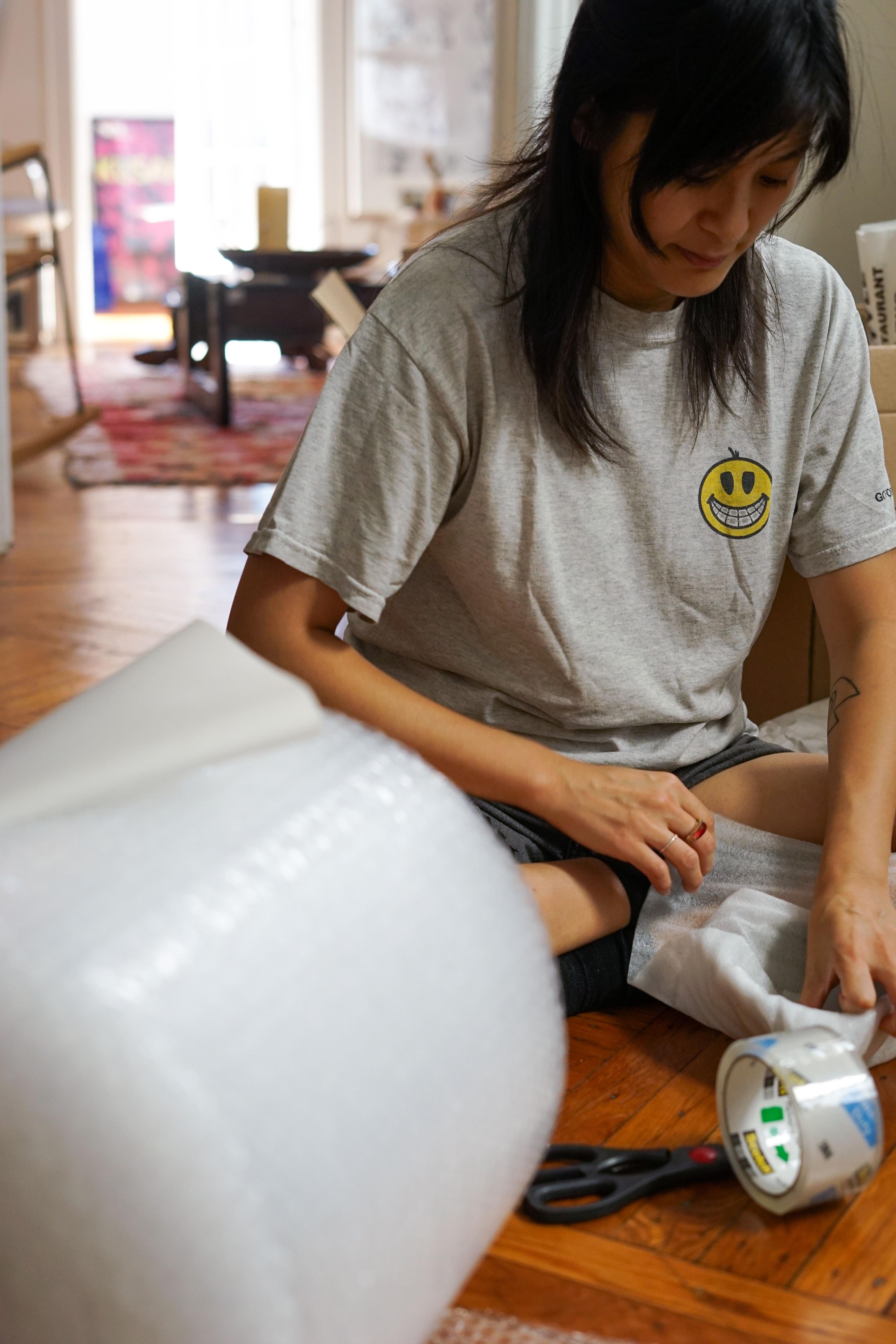 a close up of Diane sitting on the floor packing